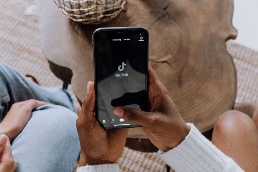 Opening the TikTok app on a smartphone held over a coffee table